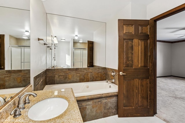 bathroom featuring ceiling fan, plus walk in shower, and vanity