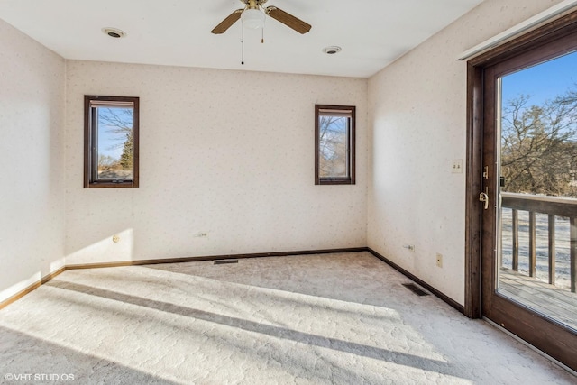 spare room with ceiling fan and light carpet