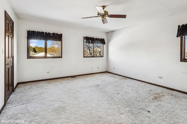 empty room featuring light carpet, ceiling fan, and plenty of natural light