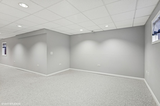 carpeted spare room with a drop ceiling