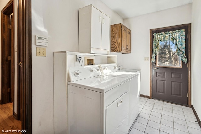 washroom with cabinets, washer and clothes dryer, and light tile patterned floors