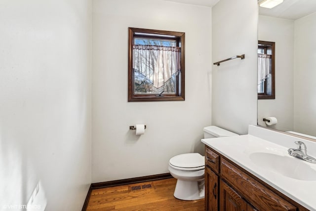 bathroom featuring wood-type flooring, vanity, and toilet