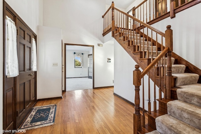 entrance foyer featuring light hardwood / wood-style floors and a towering ceiling