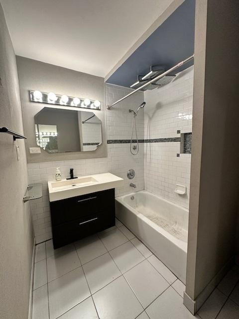 bathroom with vanity, tile patterned flooring, and tiled shower / bath