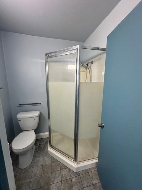 bathroom with a shower with shower door and toilet