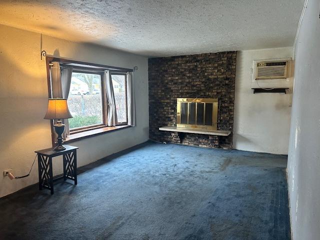 unfurnished living room with a fireplace, a textured ceiling, a wall mounted AC, and carpet flooring