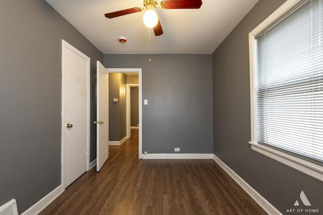 unfurnished bedroom with ceiling fan and dark hardwood / wood-style flooring