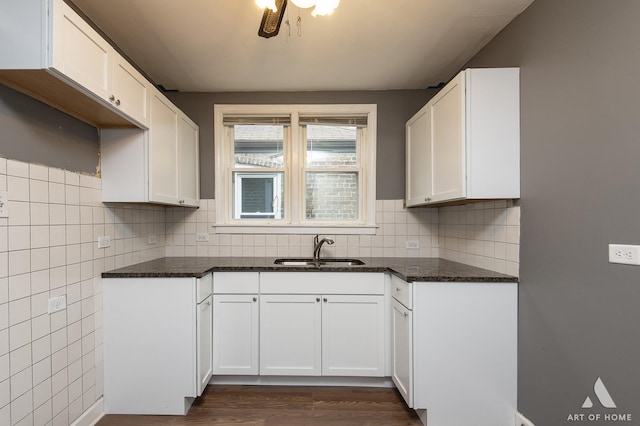 kitchen with sink, white cabinets, dark stone countertops, and dark hardwood / wood-style floors