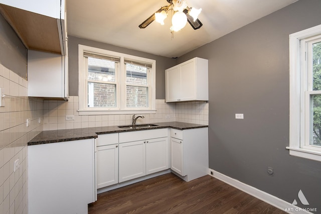 kitchen with sink, white cabinets, decorative backsplash, dark stone counters, and dark hardwood / wood-style floors