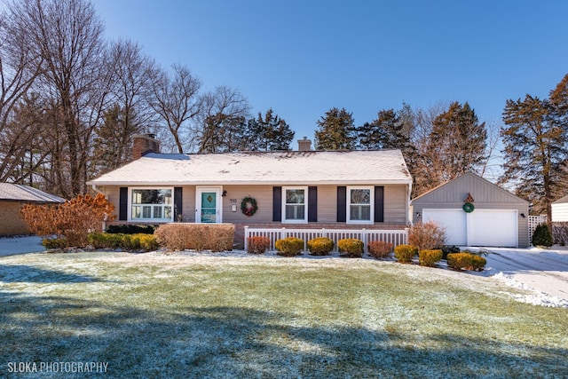 ranch-style house with a front yard, a porch, a garage, and an outbuilding