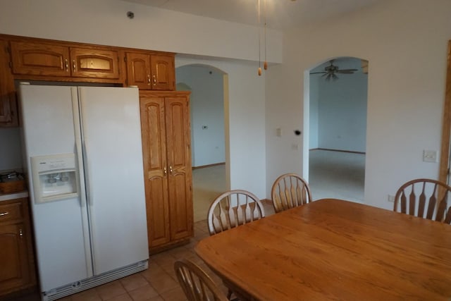 tiled dining area with ceiling fan