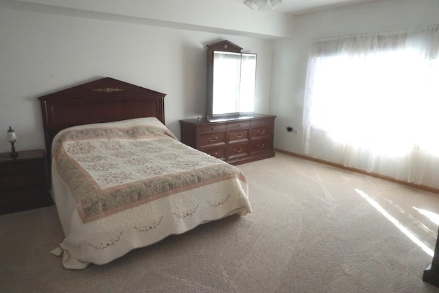 bedroom featuring light carpet and multiple windows