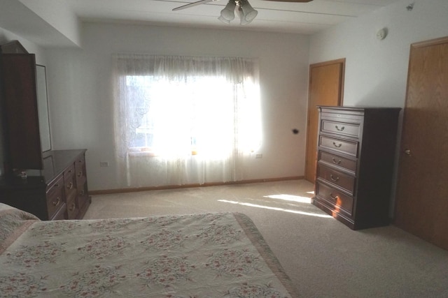 bedroom with light carpet, ceiling fan, and baseboards