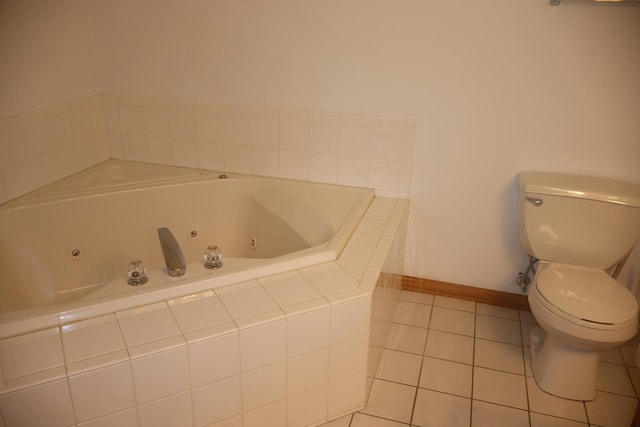 full bathroom featuring toilet, a whirlpool tub, baseboards, and tile patterned floors