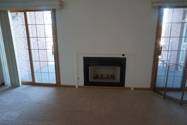 unfurnished living room with carpet floors and a healthy amount of sunlight