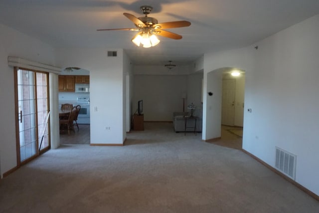 carpeted spare room featuring ceiling fan