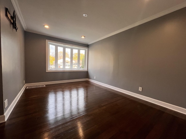 spare room with dark hardwood / wood-style flooring and ornamental molding