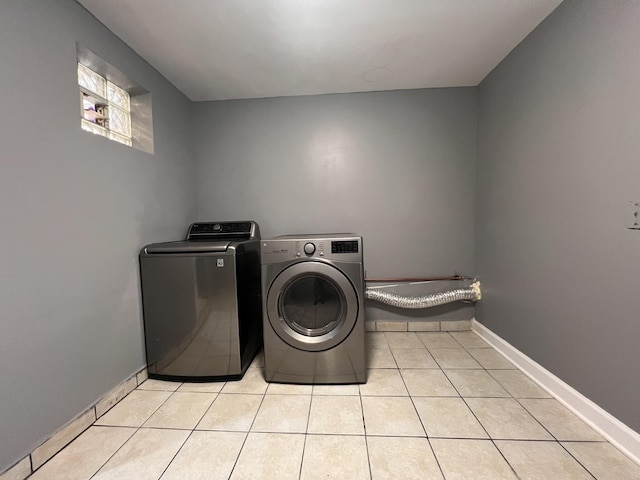 washroom with light tile patterned flooring and washing machine and clothes dryer