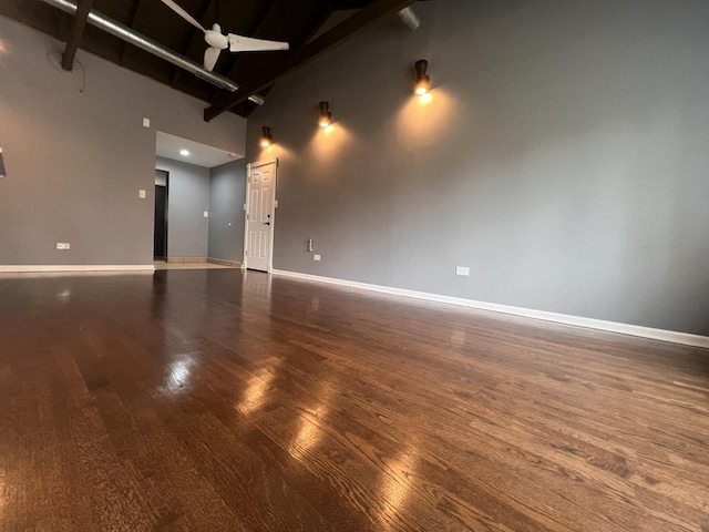 unfurnished room with a towering ceiling and dark hardwood / wood-style floors