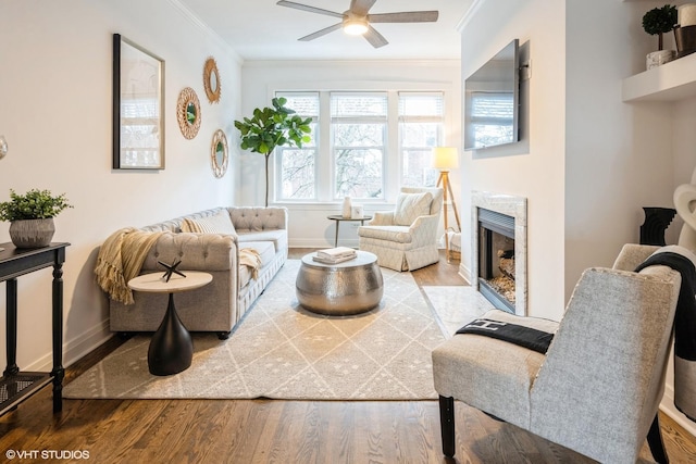 living room featuring a premium fireplace, crown molding, hardwood / wood-style flooring, and ceiling fan