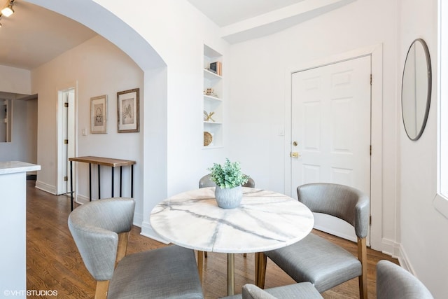 dining area with dark hardwood / wood-style floors and built in features