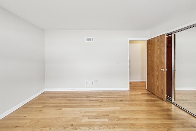 empty room with light hardwood / wood-style flooring