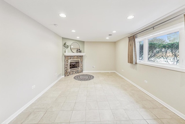 unfurnished living room with light tile patterned floors and a tiled fireplace