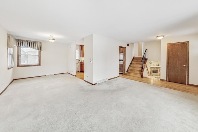 unfurnished living room with light colored carpet