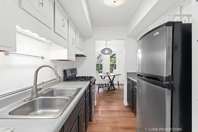 kitchen featuring dark hardwood / wood-style floors, white cabinetry, appliances with stainless steel finishes, dark brown cabinets, and sink