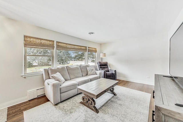 living room with hardwood / wood-style floors and a baseboard heating unit