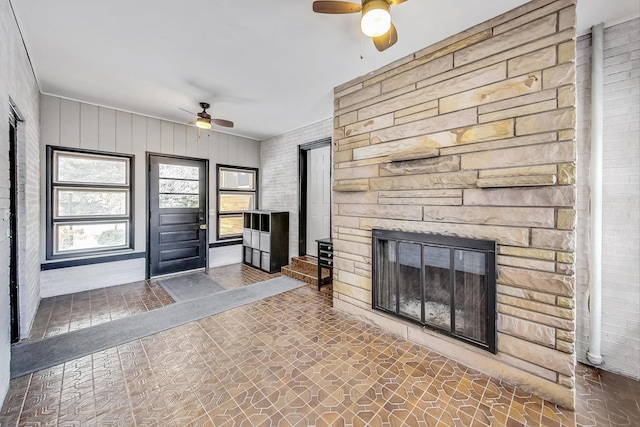 unfurnished living room featuring a fireplace and ceiling fan