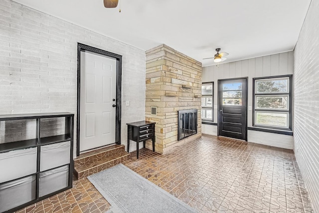 living room featuring ceiling fan and a fireplace