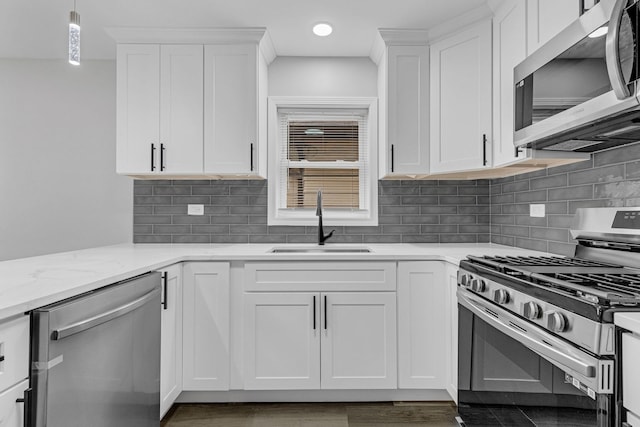 kitchen featuring stainless steel appliances, sink, decorative light fixtures, white cabinets, and light stone countertops