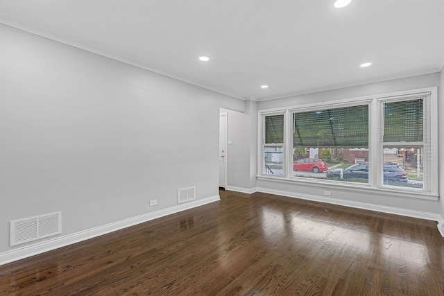 empty room with dark hardwood / wood-style flooring and crown molding