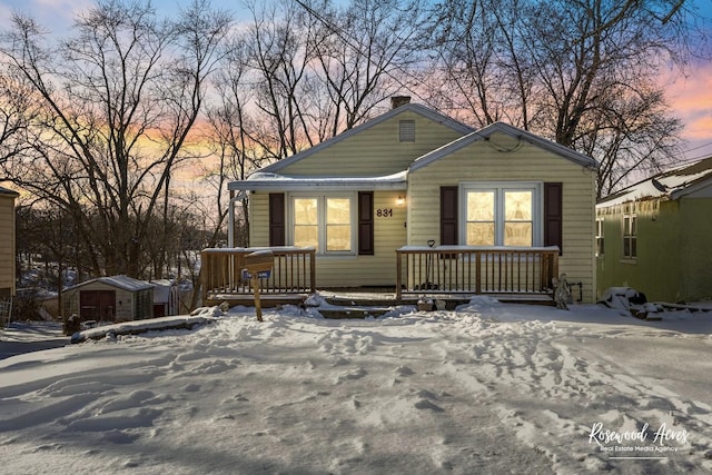 bungalow-style home with a storage unit