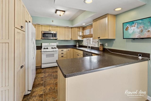 kitchen with light brown cabinetry, sink, appliances with stainless steel finishes, and kitchen peninsula