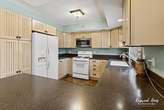 kitchen featuring sink, white appliances, and light brown cabinets