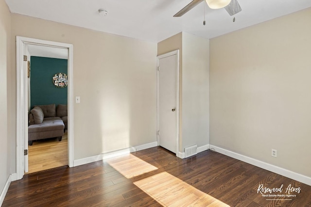 unfurnished room with ceiling fan and dark hardwood / wood-style flooring