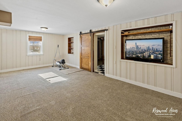 interior space with a barn door and carpet flooring