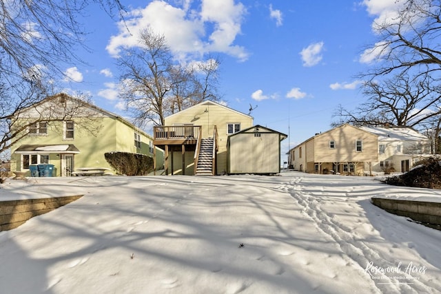 snow covered rear of property with a deck