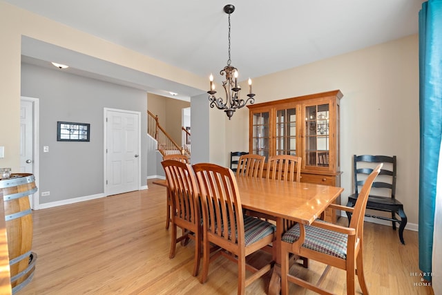 dining space with light hardwood / wood-style floors and a chandelier