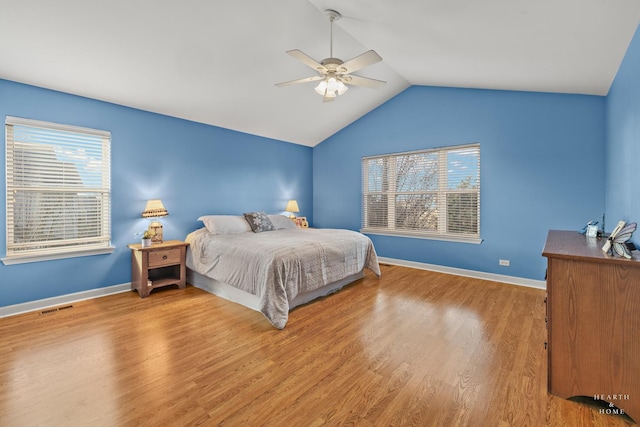 bedroom with ceiling fan, hardwood / wood-style flooring, and vaulted ceiling