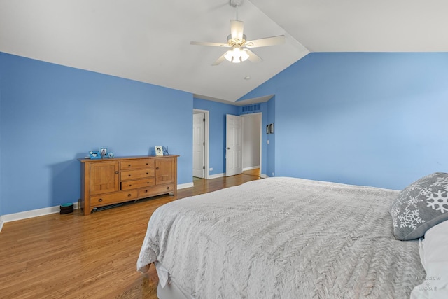 bedroom with ceiling fan, vaulted ceiling, and hardwood / wood-style flooring