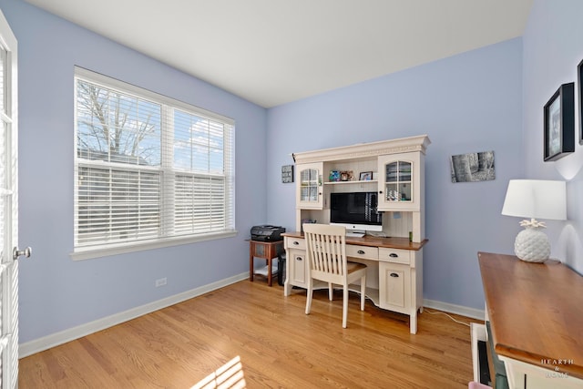 home office with light hardwood / wood-style flooring