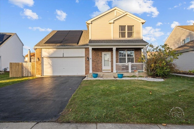 view of front of home with solar panels, covered porch, a front lawn, and a garage