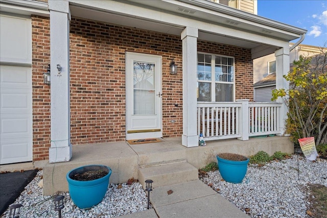 doorway to property with a porch and a garage