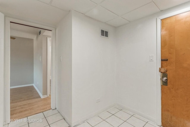 interior space featuring light tile patterned floors and a paneled ceiling