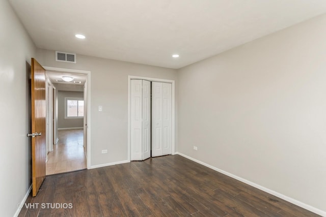 unfurnished bedroom with dark hardwood / wood-style floors and a closet