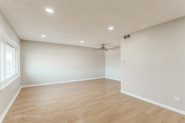 empty room with ceiling fan and light hardwood / wood-style flooring