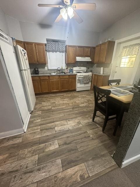 kitchen featuring white appliances, ceiling fan, sink, and dark hardwood / wood-style floors